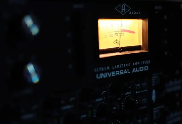 Rap & HipHop Recording 4 Close-up of professional analog audio equipment with illuminated VU meter in a recording studio