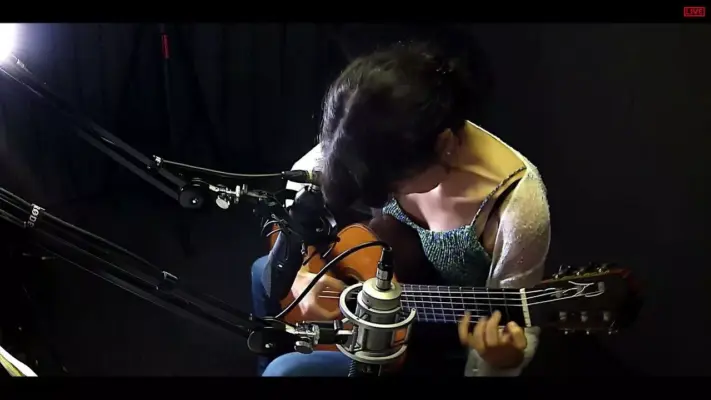 Guitar recording 1 Professional recording of an acoustic guitar using dual studio microphones at SOUNDSTARSTUDIOS Recording Studio Munich; close-up of a female guitarist during a production session.